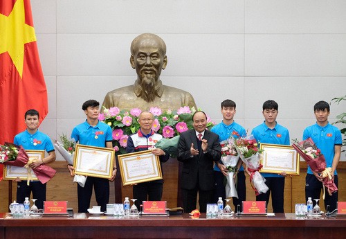 Đội trưởng Lương Xuân Trường đại diện tuyển U23 nhận HCLĐ hạng Nhất (phải)