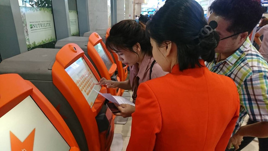 Nhân viên mặt đất hướng dẫn hành khách tự làm thủ tục check in ở sân bay Tân Sơn Nhất chỉ mất 30 giây. Ảnh minh hoạ